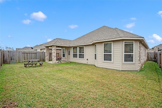 rear view of house featuring a yard