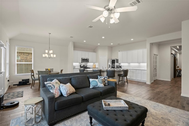 living room featuring lofted ceiling, ceiling fan with notable chandelier, and light wood-type flooring