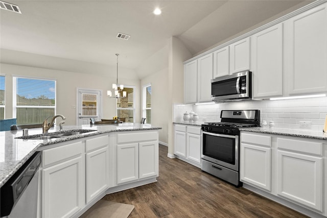 kitchen featuring appliances with stainless steel finishes, pendant lighting, sink, white cabinets, and light stone countertops