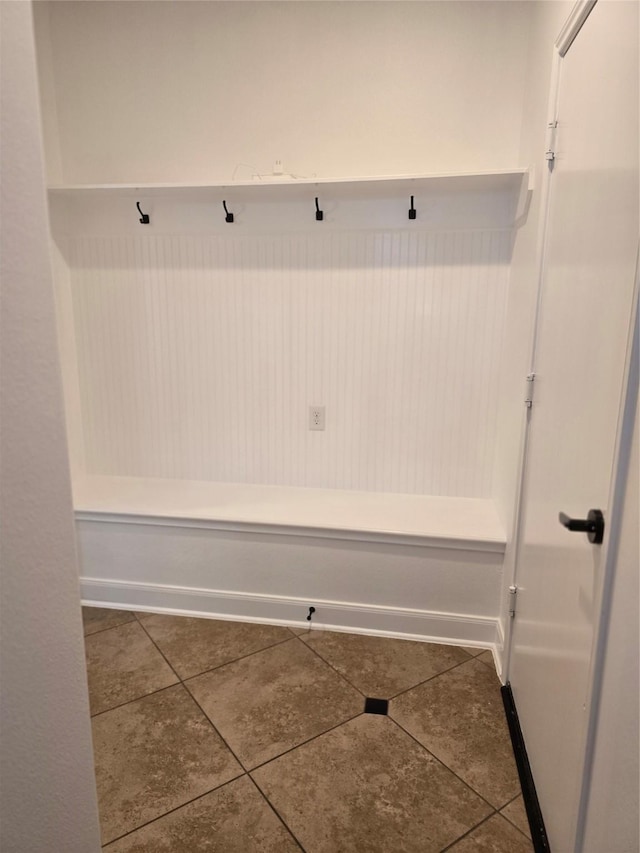 mudroom with dark tile patterned flooring