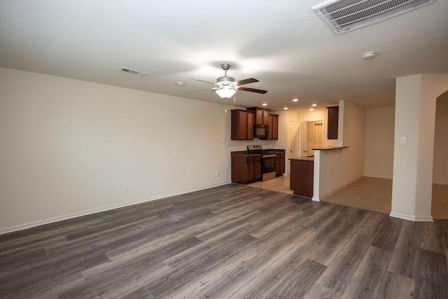 unfurnished living room with ceiling fan and dark hardwood / wood-style flooring