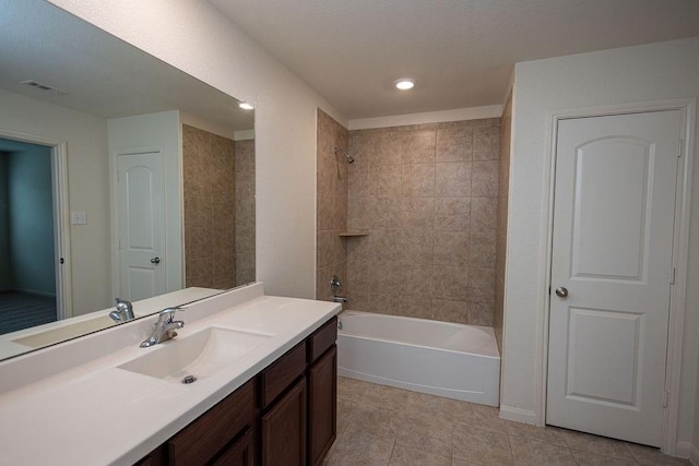 bathroom with tile patterned flooring, tiled shower / bath, and vanity