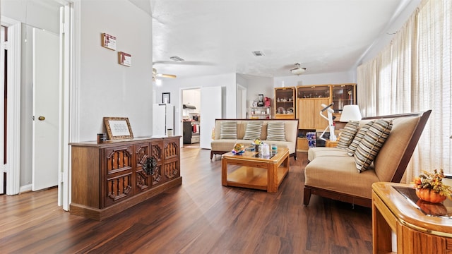 living room featuring dark hardwood / wood-style floors and ceiling fan