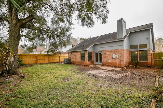 back of property featuring french doors, a lawn, and central air condition unit