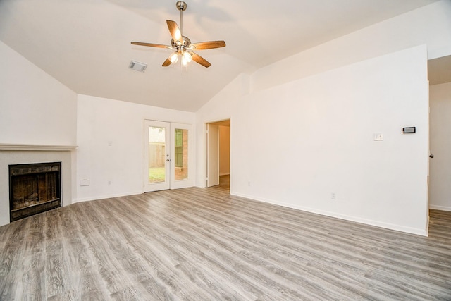 unfurnished living room with vaulted ceiling, light wood-type flooring, ceiling fan, and french doors