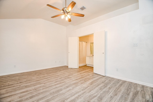 empty room with ceiling fan, light hardwood / wood-style floors, and vaulted ceiling