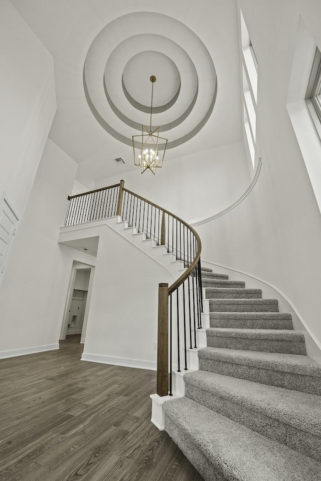 16651 Yaklin Meadow Ct, Humble, TX 77346 - staircase featuring a towering ceiling, wood finished floors, a chandelier, and a tray ceiling