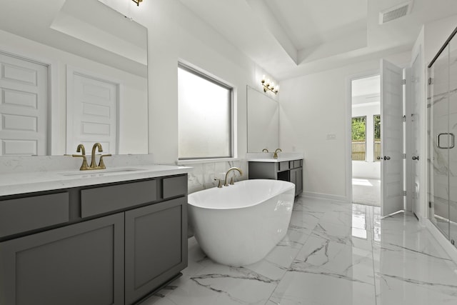 16651 Yaklin Meadow Ct, Humble, TX 77346 - bathroom featuring two vanities, a marble finish shower, a raised ceiling, and a freestanding tub