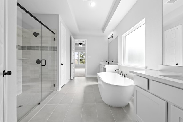 bathroom featuring a stall shower, a freestanding tub, a sink, a ceiling fan, and two vanities