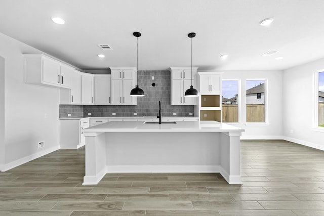 kitchen with light countertops, wood tiled floor, a sink, and visible vents