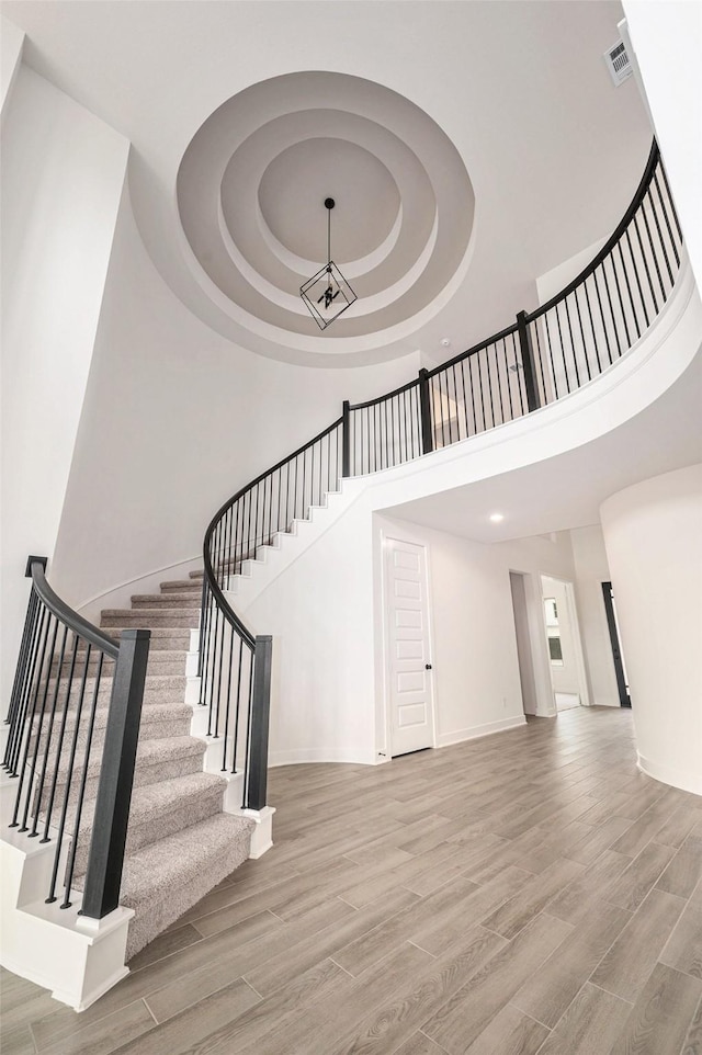 staircase with a tray ceiling and a high ceiling