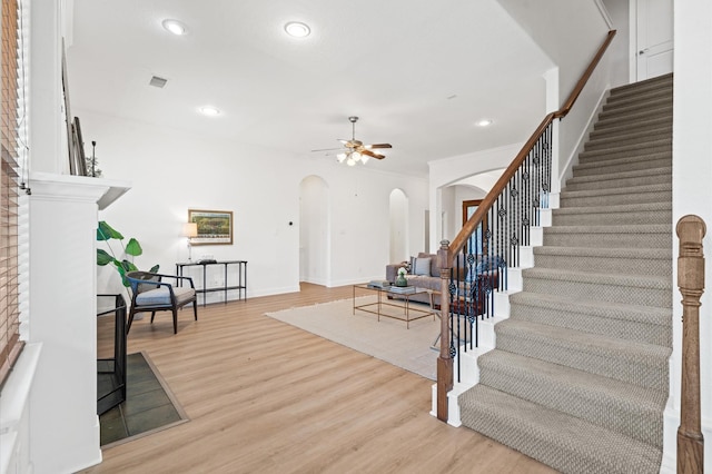 stairs featuring wood-type flooring and ceiling fan