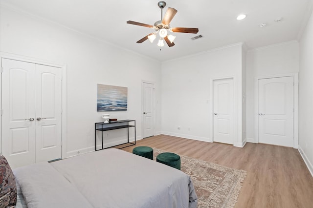 bedroom with crown molding, ceiling fan, and light hardwood / wood-style floors