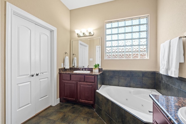 bathroom featuring vanity and tiled tub