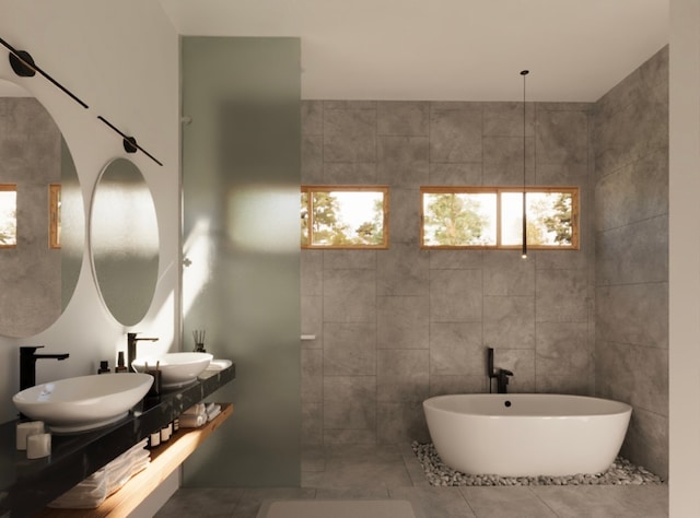 bathroom featuring a washtub, vanity, tile patterned floors, and tile walls