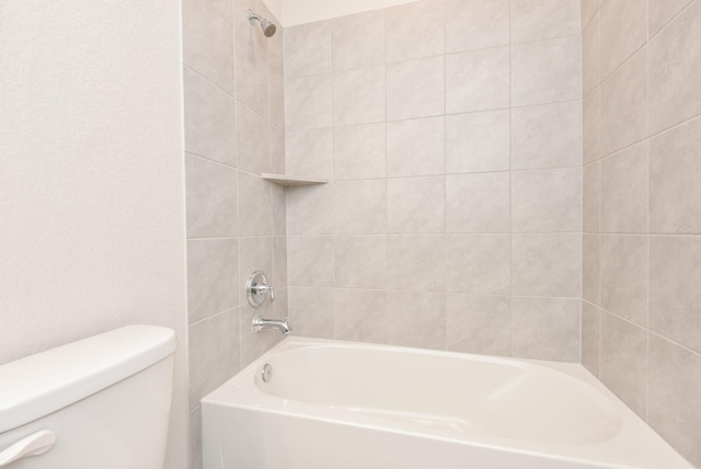 bathroom with tiled shower / bath and toilet