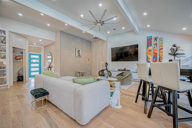 living room featuring vaulted ceiling with beams, ceiling fan, and light wood-type flooring