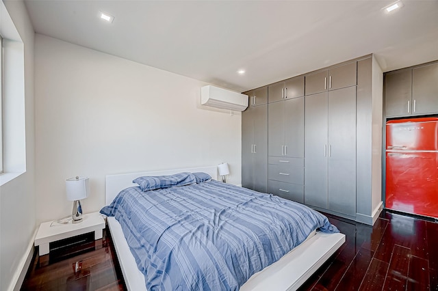 bedroom featuring a closet, dark hardwood / wood-style floors, a wall mounted AC, and refrigerator