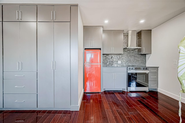 kitchen with gray cabinets, stainless steel electric stove, decorative backsplash, fridge, and wall chimney range hood