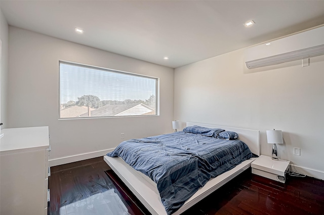 bedroom with dark hardwood / wood-style flooring and a wall mounted AC