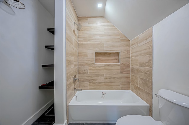 bathroom featuring tiled shower / bath and toilet