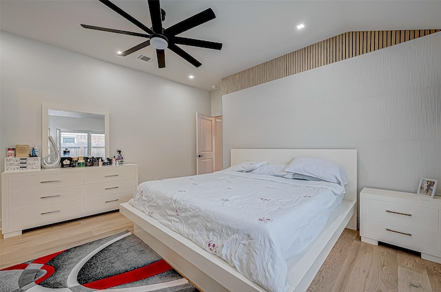 bedroom with vaulted ceiling, ceiling fan, and light wood-type flooring