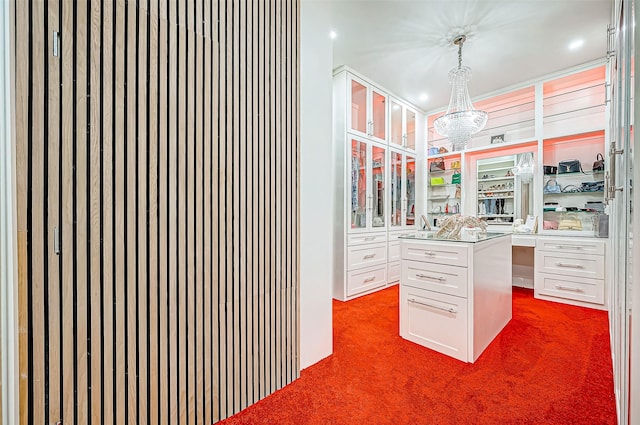 walk in closet with an inviting chandelier and dark carpet