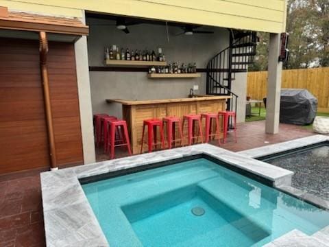 view of swimming pool with an outdoor bar and a patio