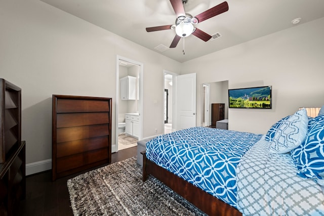 bedroom with dark wood-type flooring, ceiling fan, and connected bathroom