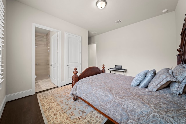 bedroom with a closet, ensuite bathroom, and wood-type flooring