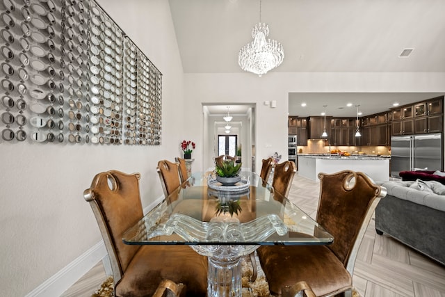 dining area featuring a notable chandelier, high vaulted ceiling, and light parquet flooring