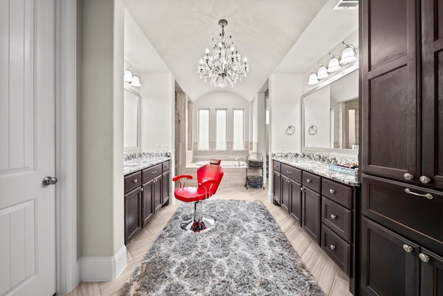 bathroom featuring vanity, a chandelier, and a washtub