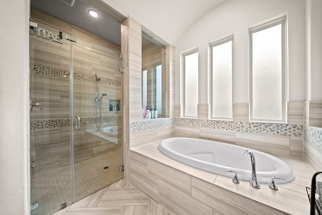 bathroom with lofted ceiling, independent shower and bath, and tile patterned flooring