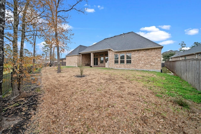 rear view of house featuring a yard