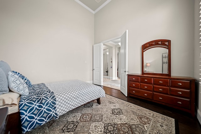 bedroom featuring crown molding, dark hardwood / wood-style floors, and high vaulted ceiling