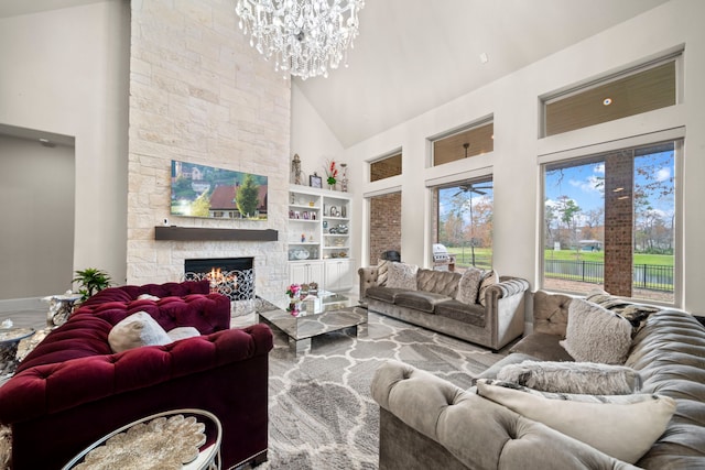 living room with a notable chandelier, high vaulted ceiling, built in features, and a fireplace