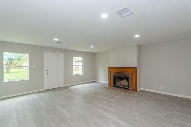 unfurnished living room featuring light hardwood / wood-style flooring and a fireplace