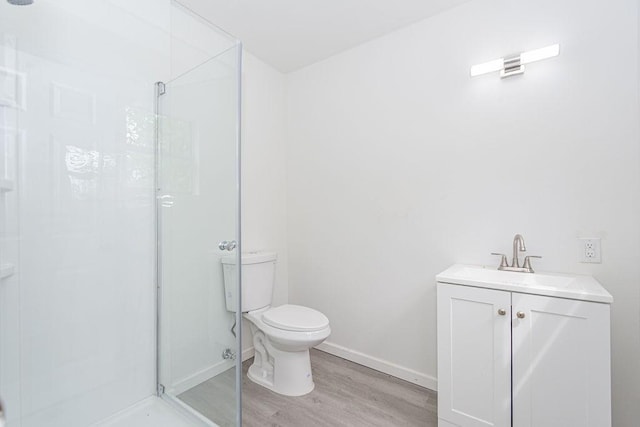 bathroom with vanity, hardwood / wood-style flooring, a shower with shower door, and toilet