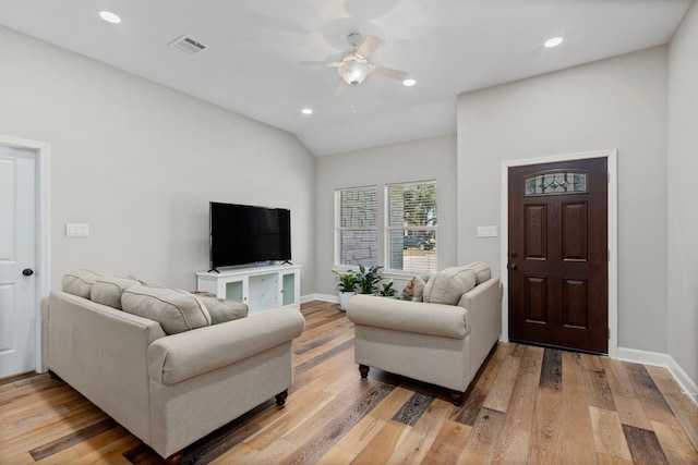 living room featuring ceiling fan, wood-type flooring, and vaulted ceiling