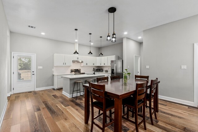 dining area featuring sink and light wood-type flooring