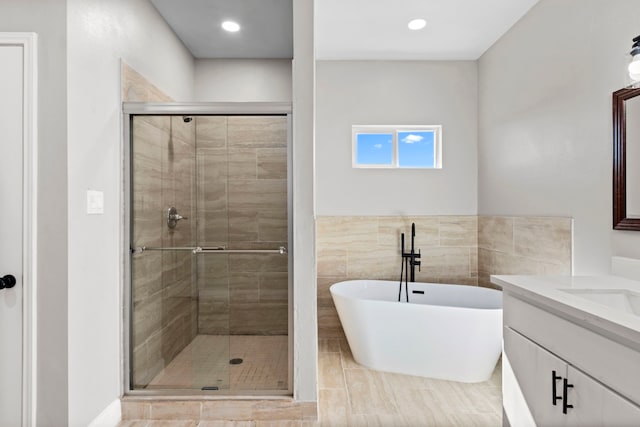 bathroom featuring vanity, shower with separate bathtub, tile walls, and tile patterned floors