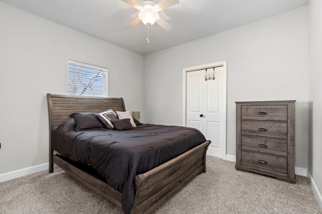 carpeted bedroom featuring ceiling fan and a closet