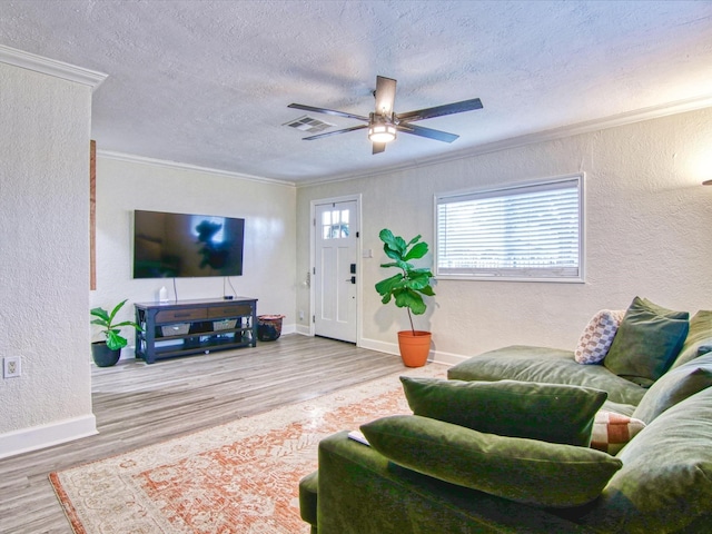 living room with hardwood / wood-style floors, crown molding, a textured ceiling, and ceiling fan