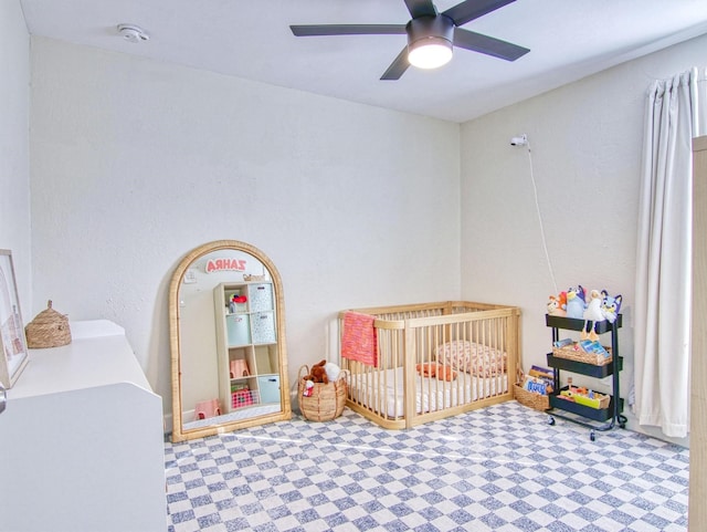 bedroom featuring a crib and ceiling fan