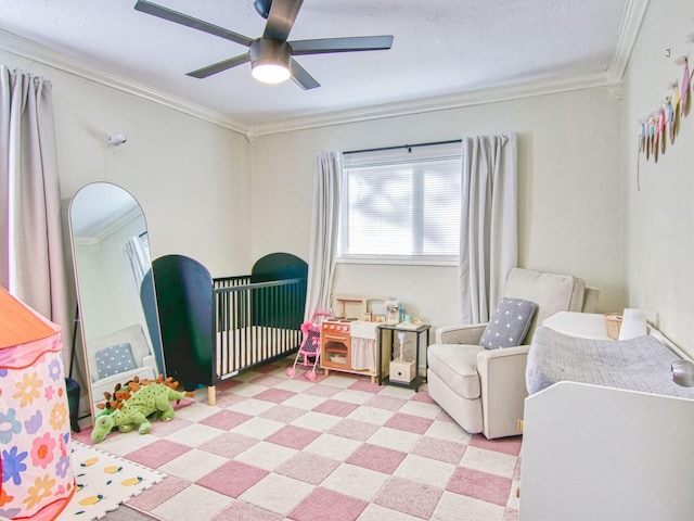 bedroom with crown molding, ceiling fan, and a crib