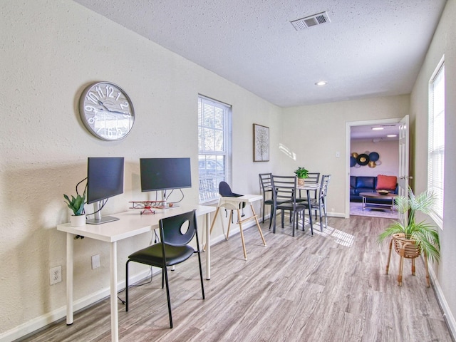 office space featuring wood-type flooring and a textured ceiling