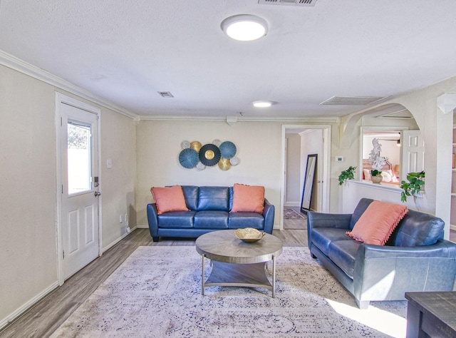 living room featuring ornamental molding, hardwood / wood-style floors, and a textured ceiling