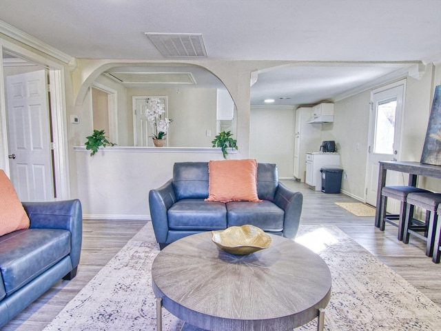 living room featuring ornamental molding and light hardwood / wood-style flooring