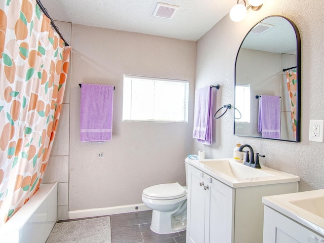 full bathroom with vanity, shower / tub combo, toilet, and a textured ceiling