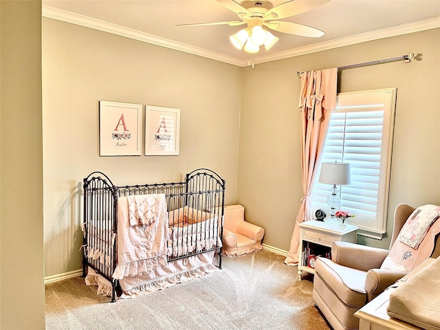 bedroom featuring a nursery area, carpet, crown molding, and ceiling fan